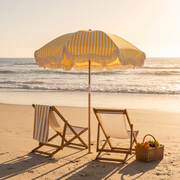Yellow Monaco beach umbrella over two beach chairs at golden hour