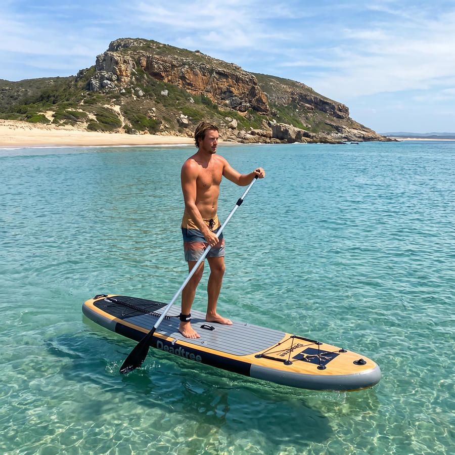 Paddling the Deadtree Odyssey SUP in clear water at Plettenberg Bay with Robberg behind