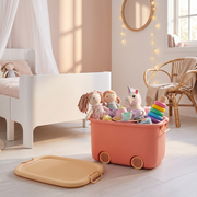 Play Time stackable storage box in coral pink, open with dolls and toys in a modern girls bedroom