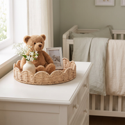 Woven wicker round tray with teddy bear and flowers in an elegant kids room