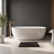 Black slatted bath mat in front of a white freestanding bath in a modern charcoal bathroom