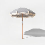 Monaco beach umbrella in dark navy and white stripe on a grey studio background