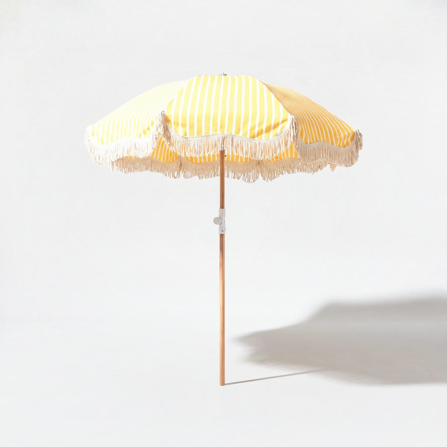 Monaco beach umbrella in yellow and white stripe on a grey studio background