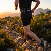 Trail runner wearing the Deadtree Stash Pack on a fynbos mountain trail