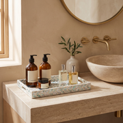 Tidal shell rectangular tray on a travertine bathroom vanity with bath products