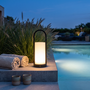 Glimmer black lantern by a pool at dusk